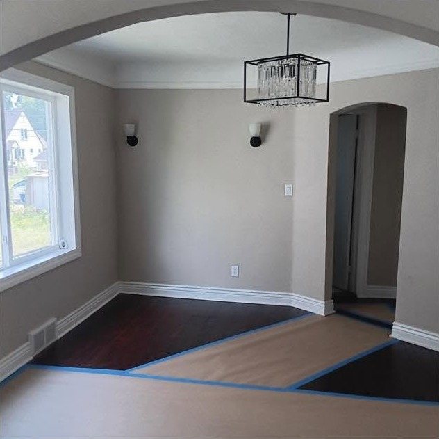 A repainted entry room with an arched opening, fresh grey walls and crisp white trim